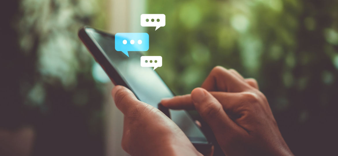 Women hand using smartphone typing, chatting conversation in chat box icons pop up. Social media maketing concept.